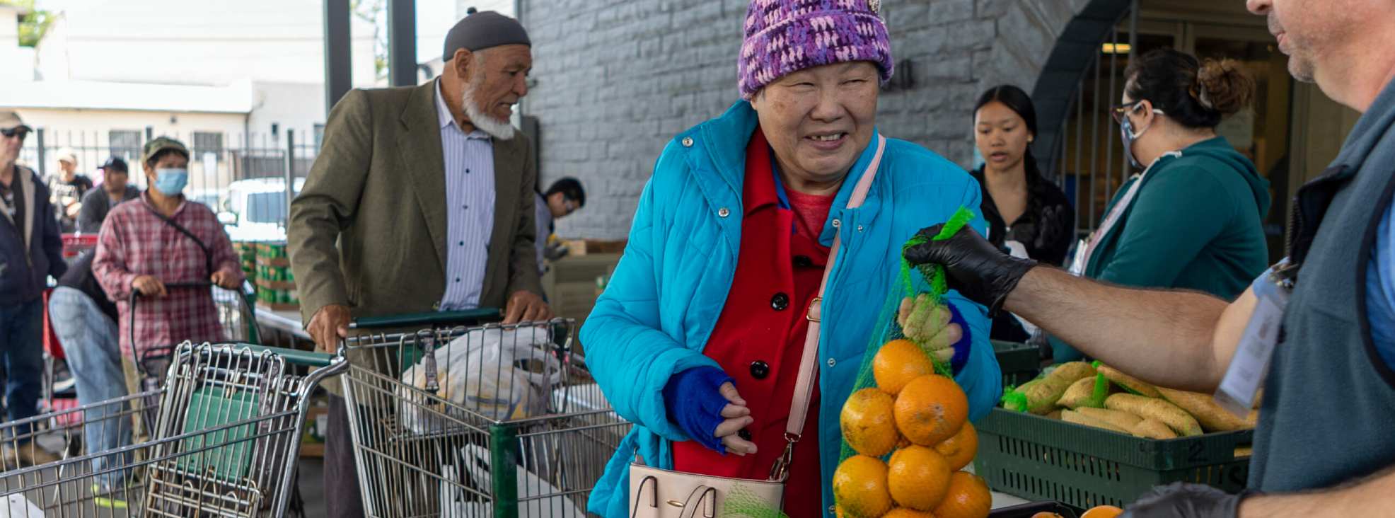 Photo of woman choosing a bag of produce.